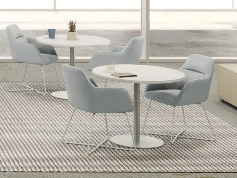 Café Table and Chairs Light gray upholstered chairs at round white café tables