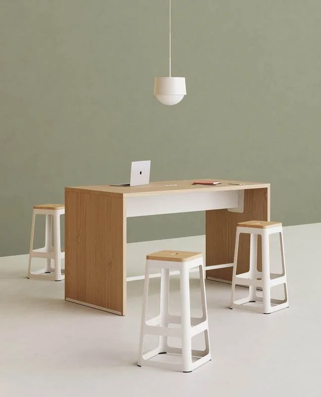 High-Top Table Oak high-top table with white stools against a sage wall