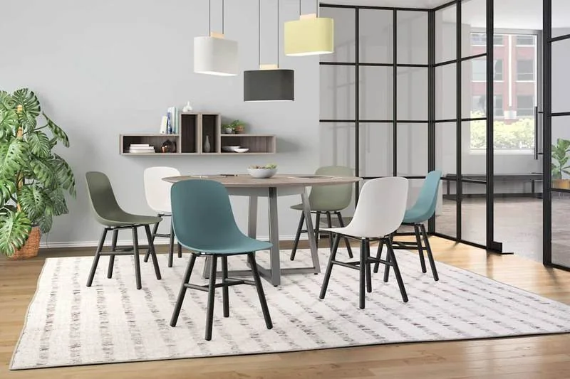 Café Table and Chairs White and gray shell chairs at a long table beneath pendant lights