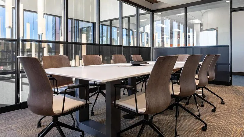 Conference Room White conference table with wood chairs in a glass meeting room