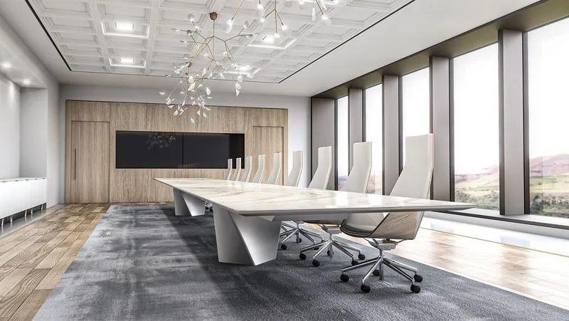 Boardroom White sculpted boardroom table under a chandelier