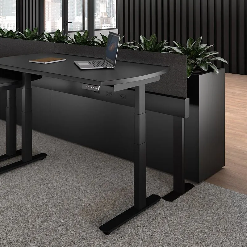 Sit-Stand Desk Black sit-stand desk beside a planter wall