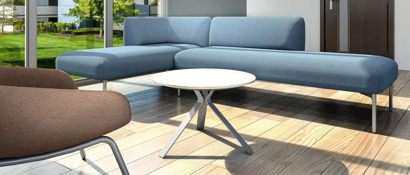 Blue sofa on slim legs in a garden lounge
