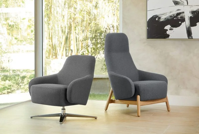 Charcoal high-back lounge chairs by tall windows