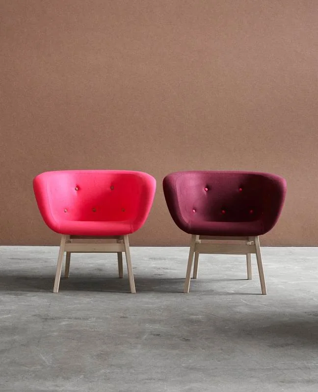 Pink and burgundy tufted lounge chairs on wood legs