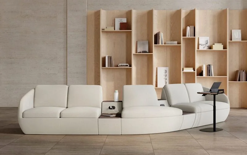 White curved modular sofa in front of oak shelving