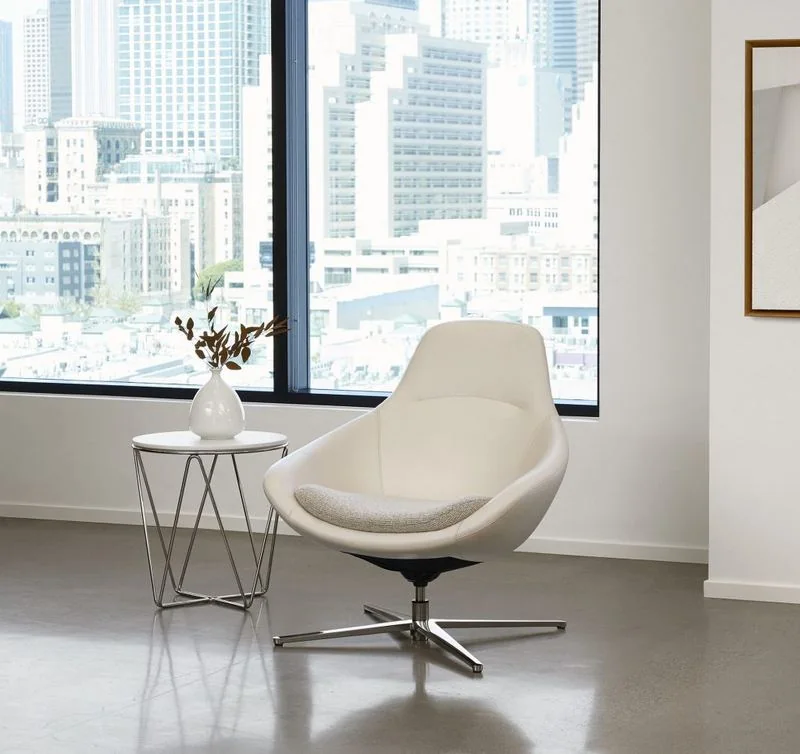 White shell swivel lounge chair by city-view windows