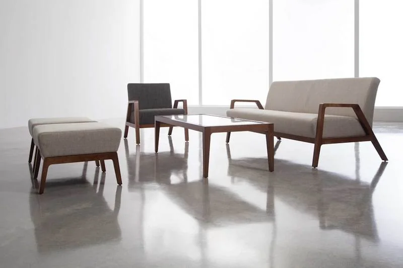 Wood-frame lounge chairs and sofa on a polished floor
