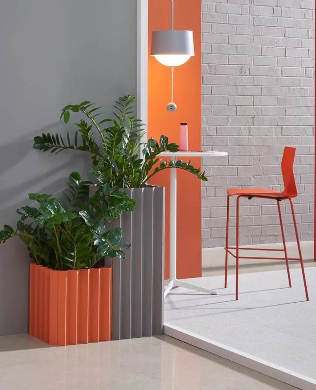 Planters Orange and gray fluted planters beside a bar table