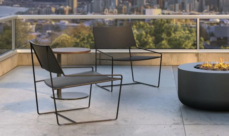 Rooftop Terrace Lounge Black-frame outdoor lounge chairs on a rooftop terrace with fire pit and skyline