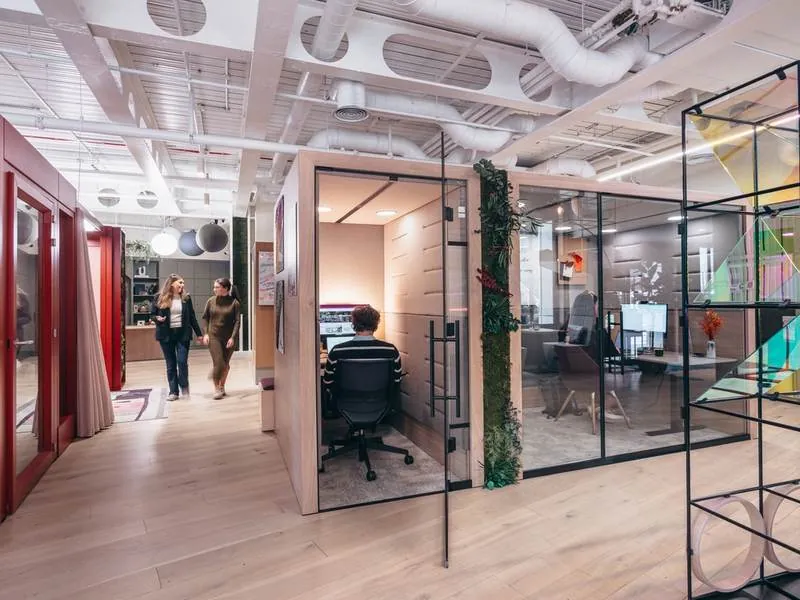 Office Pods Glass-front work pods in a busy open office