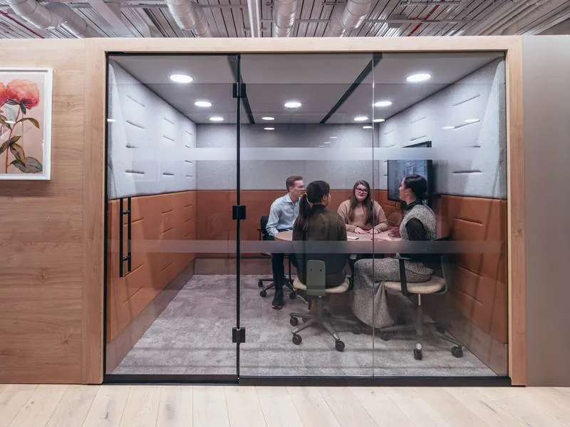 Meeting Pod Glass meeting pod with a team around a table