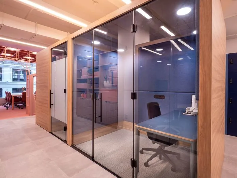 Work Pods Glass work pods with desks along a corridor