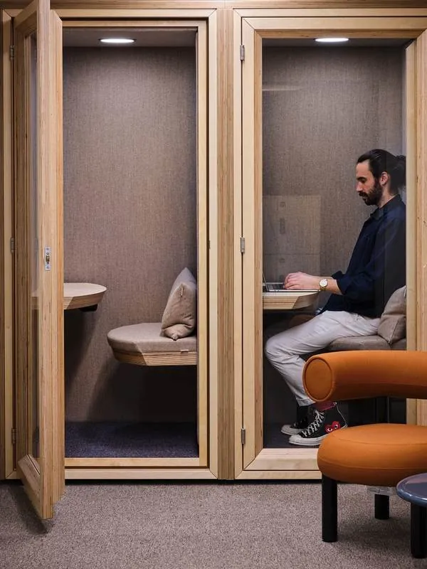 Phone Booth Man working in a wood-frame phone booth