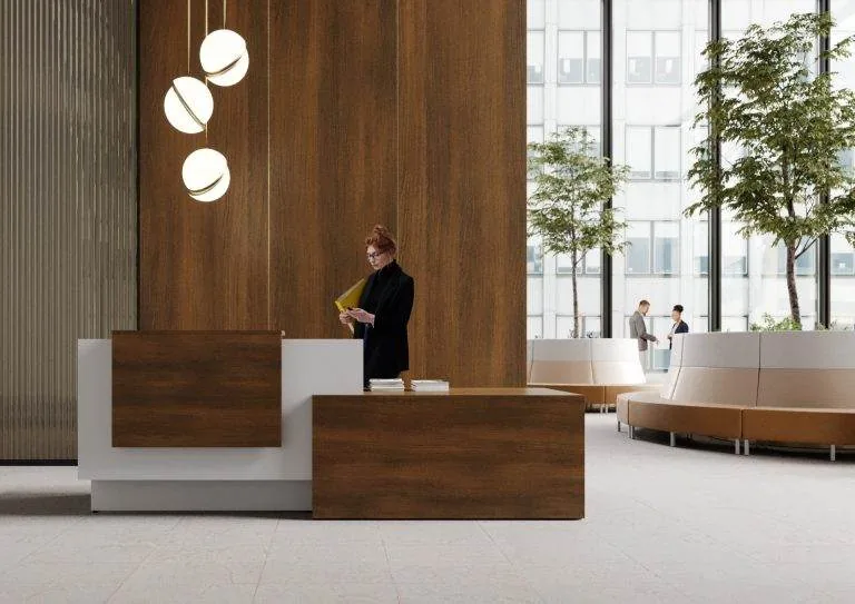 Walnut Reception Desk Walnut reception desk with globe pendant lights and greenery