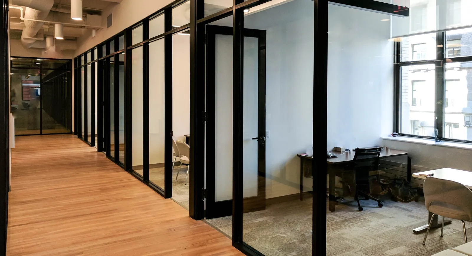 Black-Framed Glass Offices Black steel-look framed glass office fronts with doors