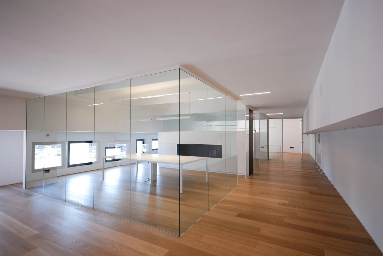 Glass Meeting Room Mono glass meeting room with full-height panels and wood floor