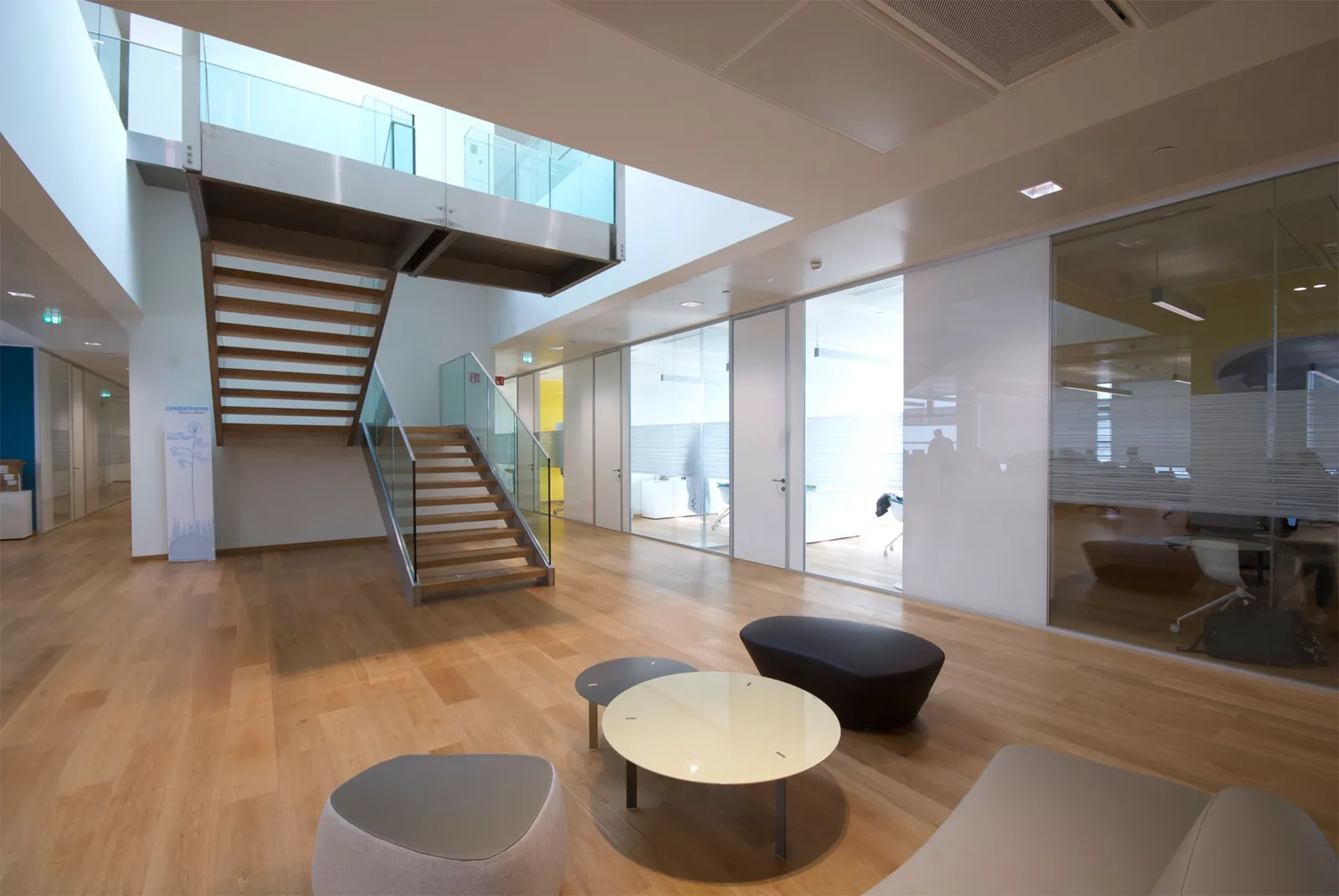 Glass Office Atrium Mono glass office fronts in a bright atrium with staircase