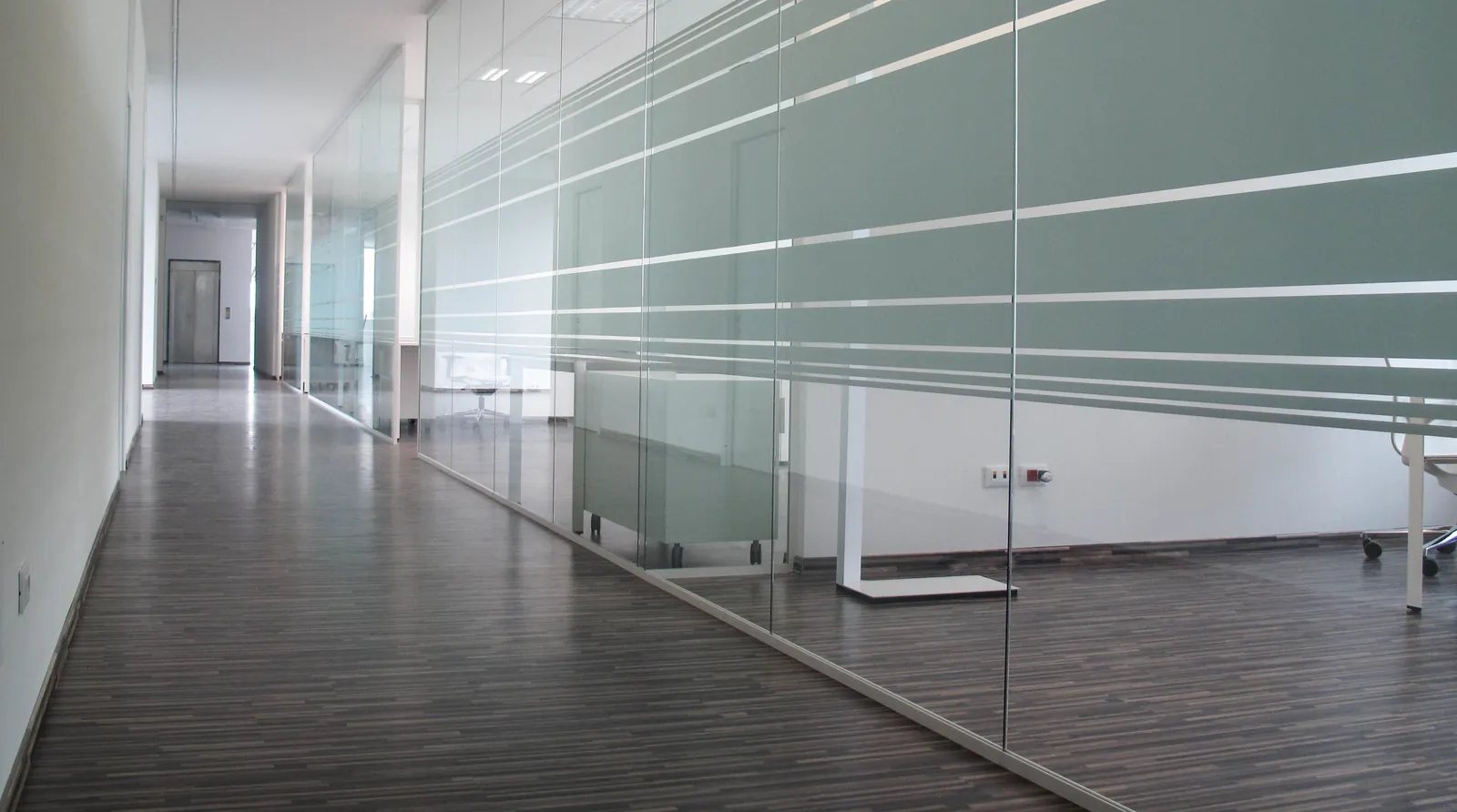 Mono Glass Corridor Mono glass partitions with frosted privacy bands along a corridor