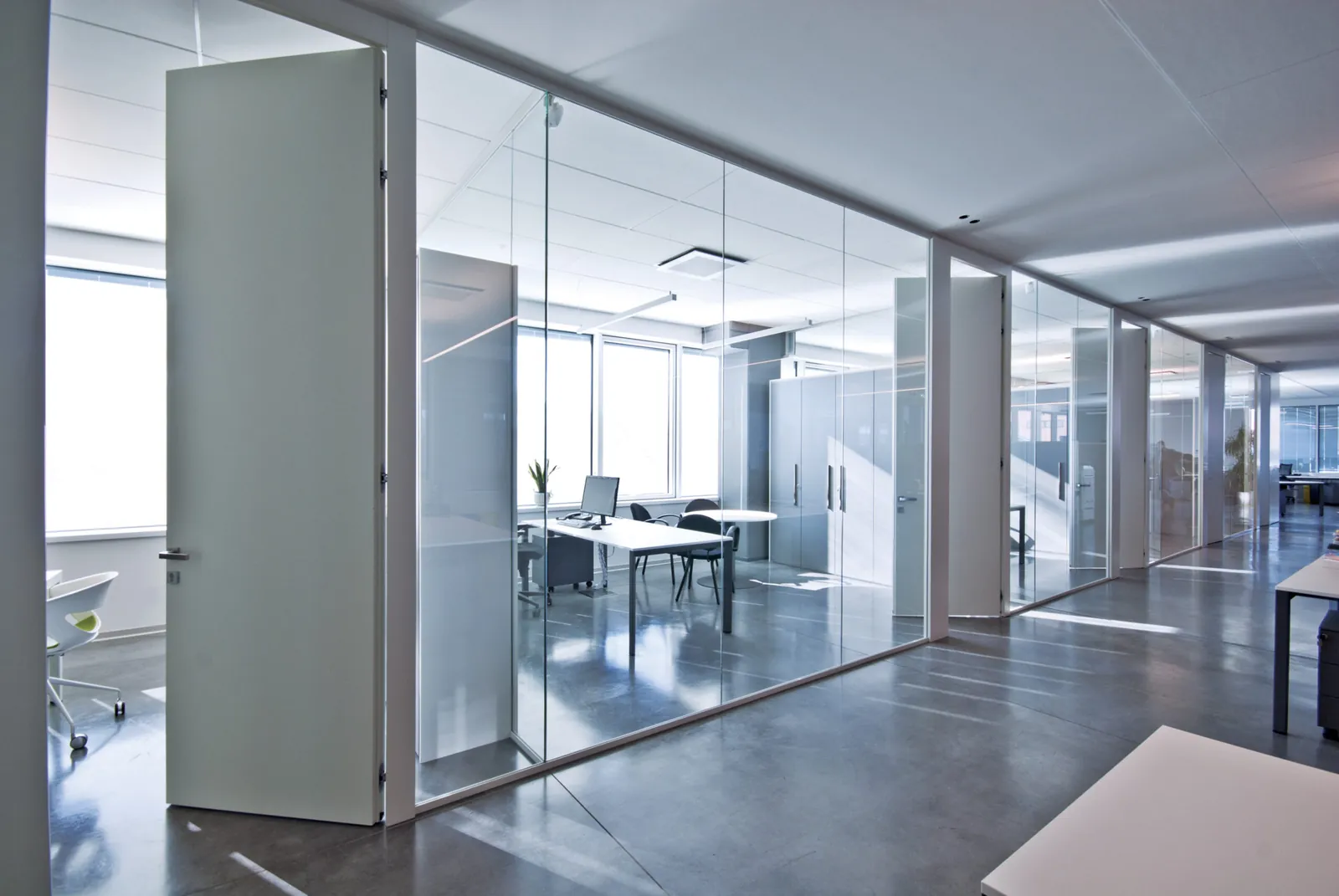 Glass and Solid Offices Glass partitions with solid door panels in an open office